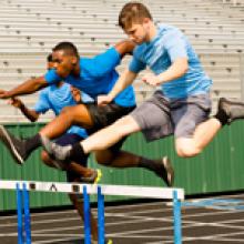 Students jumping track hurdles